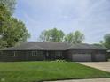 A single-story brick home on a lush green lawn and mature trees in a quiet neighborhood at 1515 Renee Dr, Plainfield, IN 46168