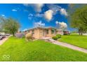 Well-kept home features lush green lawn and a tidy front entrance at 2150 Main St, Beech Grove, IN 46107