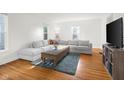 Bright living room featuring hardwood floors, large windows, a sectional sofa, and stylish decor at 2336 Sycamore St, Columbus, IN 47201
