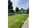 Manicured lawn with mature trees highlights the home's exterior at 2407 Overlook Dr, Shelbyville, IN 46176