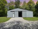 Large silver barn with a gravel driveway and a sliding door at 2548 N Letterman Rd, Paragon, IN 46166