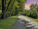 Gravel driveway lined with mature trees leading to the serene and private property at 2548 N Letterman Rd, Paragon, IN 46166