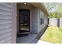 Inviting front entrance with a glass storm door, neutral siding, and a glimpse of the landscaped yard at 320 Red Tail Ln, Indianapolis, IN 46241