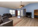 Spacious living room with vaulted ceilings, hardwood floors, and a cozy seating area with a leather sofa at 320 Red Tail Ln, Indianapolis, IN 46241