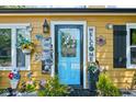 Inviting front door with welcoming decorations, including potted plants and decorative art at 3433 Brewer Dr, Indianapolis, IN 46222