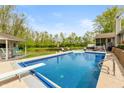 Stunning backyard featuring a large pool, diving board, and an adjacent lounge area with chairs at 35 Valley View, Brownsburg, IN 46112
