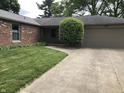 Close up of home's entrance featuring well-maintained yard and tan garage door at 3619 31St St, Columbus, IN 47203