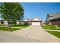 Inviting home with a brick and siding exterior, a two-car garage, and a green lawn at 40 Clear Spring Ln, Trafalgar, IN 46181