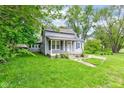 Quaint gray home with covered porch and lovely front lawn at 42 E Brookville Rd, Fountaintown, IN 46130