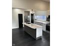 Modern kitchen with a large island, white cabinets, stainless steel appliances, and dark hardwood floors at 44 S Butler Ave, Indianapolis, IN 46219