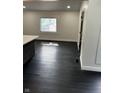 Bright kitchen area featuring dark hardwood floors, a large window, and neutral wall colors at 44 S Butler Ave, Indianapolis, IN 46219