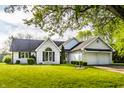 Inviting two-story home featuring a lush green lawn, arched window, and an attached two-car garage at 51 Glasgow Ln, Noblesville, IN 46060