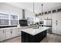 This kitchen has modern white cabinetry, a black island, stainless steel appliances, and lots of natural light at 525 Fynn Pl, Indianapolis, IN 46202