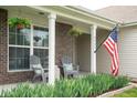 Cozy front porch with hanging plants, seating, and a patriotic American flag display at 5957 Haywood Ct, Greenwood, IN 46142