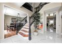 Elegant foyer with marble floors, staircase with dark railings, and views into multiple living spaces at 6374 Timberbluff Cir, Avon, IN 46123