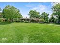 Expansive front yard featuring well-maintained lawn and mature trees surrounding property at 665 Spring Hills Dr, Zionsville, IN 46077