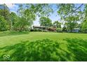Lush lawn in front yard with mature trees surrounding home at 665 Spring Hills Dr, Zionsville, IN 46077