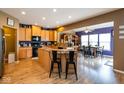 Open-concept kitchen and dining area with wood floors, an island with seating, and modern appliances at 6683 School Branch Dr, Brownsburg, IN 46112
