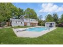 Expansive backyard featuring a refreshing in-ground pool, lush greenery, and a patio area at 6839 Chaucer Ct, Indianapolis, IN 46220