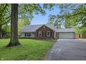Traditional home with brick accents, an attached garage, and a well-manicured front lawn at 6839 Chaucer Ct, Indianapolis, IN 46220