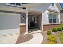 Close-up of front entrance with brick accents, covered porch, and attached garage at 7234 Darley Ln, Indianapolis, IN 46259