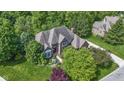 Aerial view of a well-maintained brick home featuring mature landscaping and a private setting at 7372 Fox Hollow Rdg, Zionsville, IN 46077