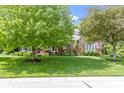 Charming brick home showcasing a neatly manicured lawn with mature trees at 7372 Fox Hollow Rdg, Zionsville, IN 46077