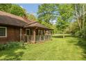 Cozy cabin exterior showcasing a welcoming covered porch, rustic details, and a vibrant green lawn at 7730 Bear Creek Rd, Morgantown, IN 46160