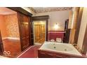 Ornate bathroom with jacuzzi tub and large glass-enclosed shower, with red accent tiles at 866 Fletcher Ave, Indianapolis, IN 46203