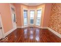 Living room showcasing hardwood floors, and bay window, bathed in natural light at 866 Fletcher Ave, Indianapolis, IN 46203