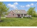 Beautiful exterior view of a brick and siding home with a well-maintained lawn and mature trees at 902 Racetime Rd, Westfield, IN 46074