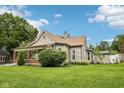 Inviting home featuring vinyl siding, a brick-columned porch, and a sprawling lawn with manicured landscaping at 910 E Pike St, Martinsville, IN 46151