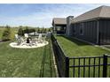 The backyard boasts a fire pit surrounded by Adirondack chairs, pool, and lush lawn at 920 Alba Dr, Lebanon, IN 46052