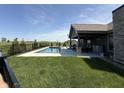 Backyard featuring an in-ground pool, patio area, outdoor kitchen, and well-maintained landscaping at 920 Alba Dr, Lebanon, IN 46052