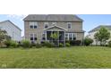 Expansive backyard featuring a screened-in porch, lush green lawn, and manicured landscaping at 952 Workington Cir, Westfield, IN 46074