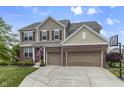 Charming two-story home featuring brick and siding, a well-manicured lawn, and an attached two-car garage at 952 Workington Cir, Westfield, IN 46074