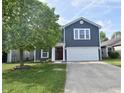 Inviting two-story home with a well-manicured lawn and a driveway leading to a two-car garage at 9613 W Stargazer Dr, Pendleton, IN 46064