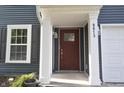 Close-up of front porch with dark-stained front door, white columns, and house number at 9613 W Stargazer Dr, Pendleton, IN 46064