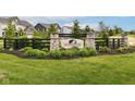 Stone and black-fence community sign, 'Steeplechase,' amidst lush green landscaping, showcasing the neighborhood's entrance at 9860 Gallop Ln, Fishers, IN 46040
