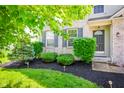 Manicured front yard showcasing lush landscaping, mulch beds, and a welcoming entrance to the home at 10075 Niagara Dr, Fishers, IN 46037