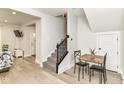 Inviting entryway with hardwood floors, staircase, and dining nook with table at 1043 N Beville Ave, Indianapolis, IN 46201