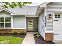 Close-up of the entrance with a decorative glass door and well maintained landscaping at 10551 Huckleberry Ct, Noblesville, IN 46060