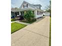 View of a charming home with a long driveway leading to a detached garage at 106 S Denny St, Indianapolis, IN 46201