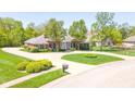 Beautiful brick home with a circular driveway, mature trees, and well-manicured landscaping at 1105 Deer Creek Dr, Anderson, IN 46011