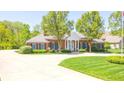 Charming brick home with a circular driveway and a well-maintained lawn, showcasing curb appeal at 1105 Deer Creek Dr, Anderson, IN 46011