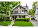 Charming two-story home featuring a well-manicured lawn and inviting front porch at 114 E 44Th St, Indianapolis, IN 46205