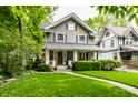 Charming two-story home featuring a well-manicured lawn and inviting front porch at 114 E 44Th St, Indianapolis, IN 46205