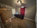 Bedroom featuring gray walls, carpet, and a simple bed, requiring repairs and updates to maximize its potential at 1314 Laurel St, Indianapolis, IN 46203