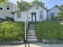 Charming home featuring a quaint facade, concrete steps, and overgrown lawn, ready for renovation and landscaping at 1314 Laurel St, Indianapolis, IN 46203