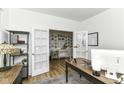Bright home office with french doors leading to another room with a collection of photos on the wall at 19442 Honeylocust Glen, Noblesville, IN 46062